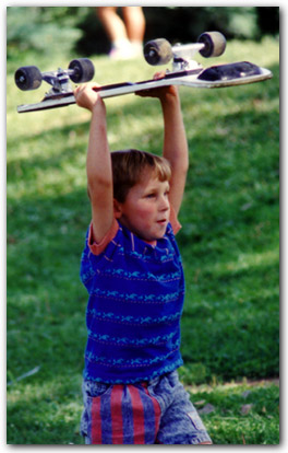 [Picture of Cole hoisting a skateboard overhead